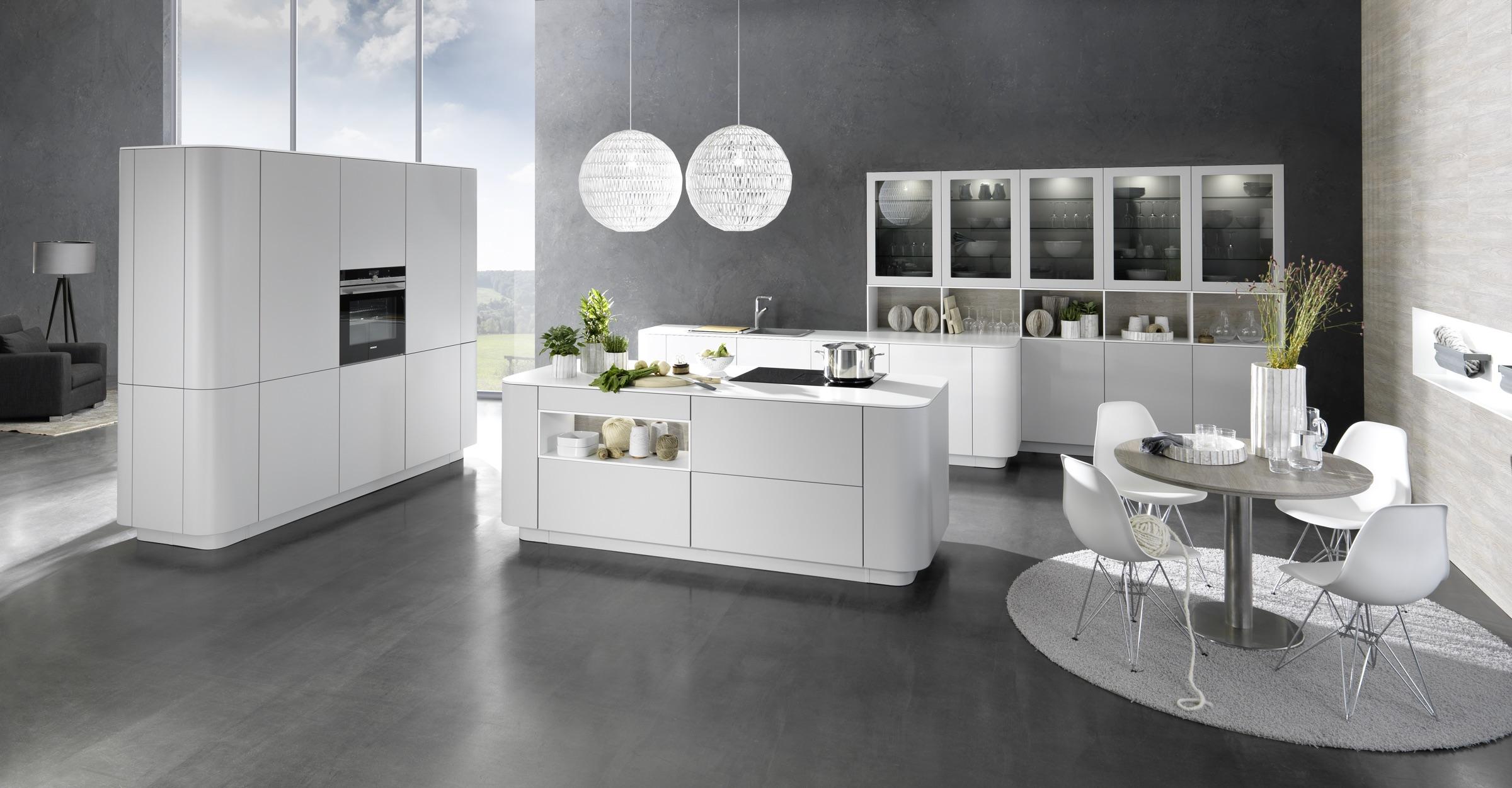 Rational 'Cambia' kitchen in soft grey with a rounded island and glazed display cabinets
